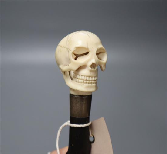 A Victorian ebonised walking cane with ivory skull hand-piece, length 87cm